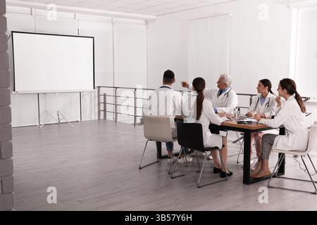 Team of doctors using video projector during conference indoors Stock Photo