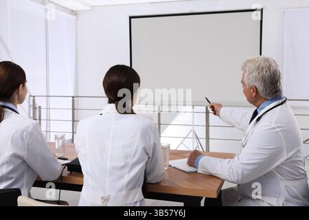 Team of doctors using video projector during conference indoors Stock Photo