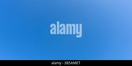 Beautiful light blue sky without clouds in the morning or afternoon on sunny day is used as natural background texture in decorative art work. Stock Photo