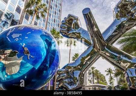 Miami Beach Florida,Lincoln Road Mall,public art installation,blue metallic globe sculpture,chrome silver sculpted fists arms crossed,modern outdoor s Stock Photo