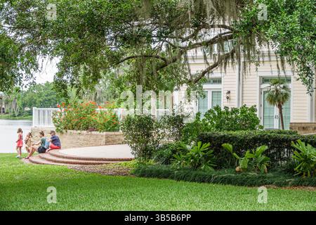 Orlando Florida,Harry P Leu Gardens,botanical garden,Lake Rowena,visitor center main building,family mother father girls children,sitting relaxing out Stock Photo