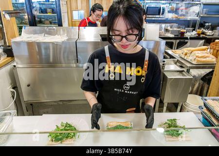 Orlando Florida,East Colonial Drive,Little Vietnam,Mills Market,food court,Asian woman worker,food preparation counter,wearing black gloves and apron, Stock Photo