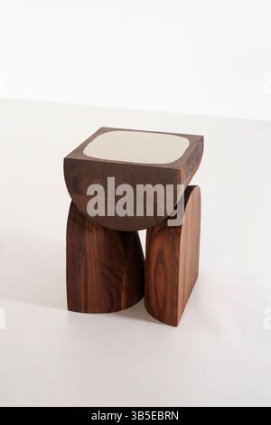 elegant wooden stool showcases a unique geometric design its minimalist style complements modern interiors, ideal for home décor enthusiasts seeking c Stock Photo