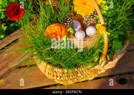 Vibrant Easter basket filled with colored eggs, fresh flowers, and greenery, showcasing a festive spring theme. Ideal for seasonal promotions and deco Stock Photo