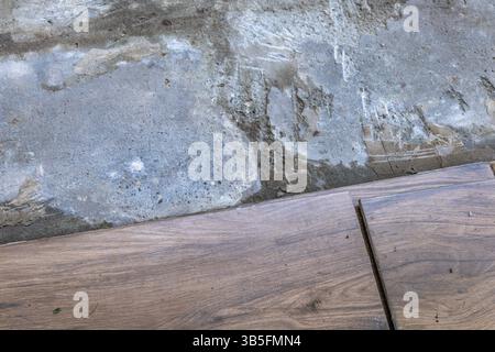 Laying tiles on a terrace in the garden, gluing tiles with frost-resistant glue on a veranda under a pergola at the house Stock Photo