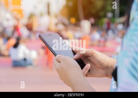Close-up image of female hands using smartphone at city shopping street, searching or social networks concept Stock Photo