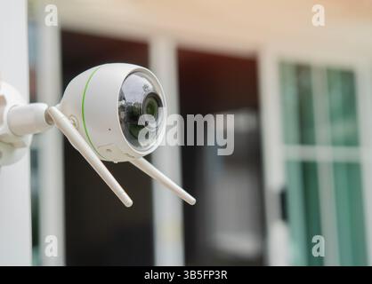 Close up object shot of a modern Wi-Fi surveillance camera oparating outside of the house. Copy space. Stock Photo