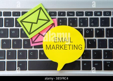 Speech bubble with text EMAIL MARKETING on laptop keyboard. Business concept. Stock Photo