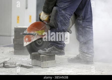 Road worker cuts concrete with a concrete cutting machine Stock Photo ...