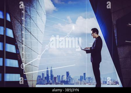 Businessman using laptop with graph statistical analysis, Business success concept Stock Photo