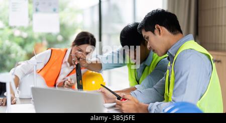 Green Tech and Engineering Collaboration. Engineers working on sustainable construction plans. Stock Photo