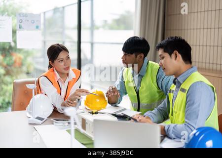 Green Tech Collaboration and Planning. A team of engineers discussing sustainable solutions in a modern office. Stock Photo