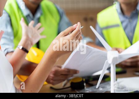 Green tech engineers brainstorming ideas for wind turbine projects Stock Photo