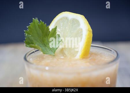Fresh lemonade with ginger decorated with green celery leaves and lemon on the dark background Stock Photo