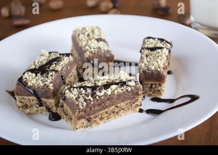 Chocolate cake with walnut cut into squares served on whiteplate Stock Photo