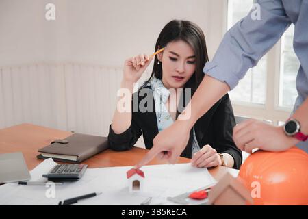 Group of two coworkers working with blueprint in office. co-working teamwork concept. Stock Photo