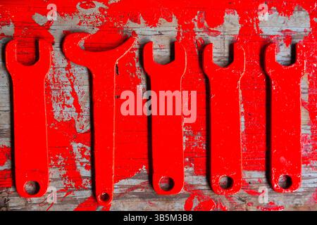 Red spanners on wooden background painted with red paint. Stock Photo