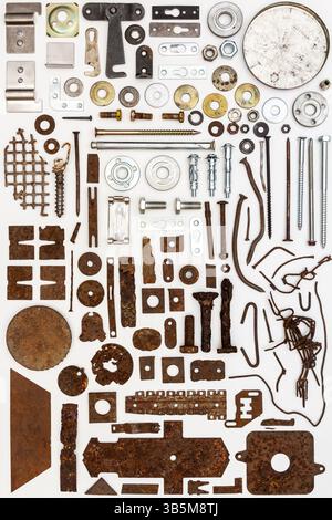 A group of various old and new bits and pieces arranged on white. Old rusty nuts, bolts, nails and other parts flay lay on white background. Stock Photo