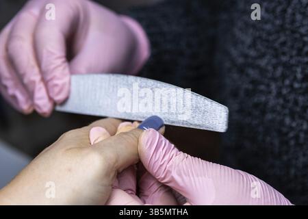 Close-up of nail filing, with a focus on hands and nail file Stock Photo