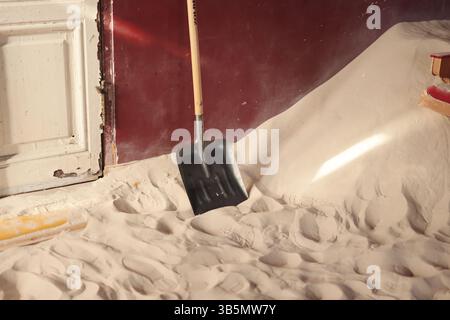 A Shovel is Resting on a Soft Sandy Floor located within an Indoor Environment Space Stock Photo