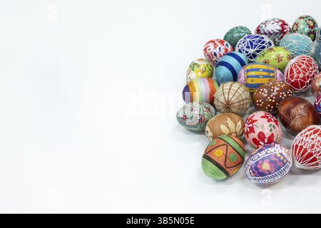 A simple Easter composition with a blank space to fill. Different colored traditional Easter eggs isolated from a white background lie side by side Stock Photo