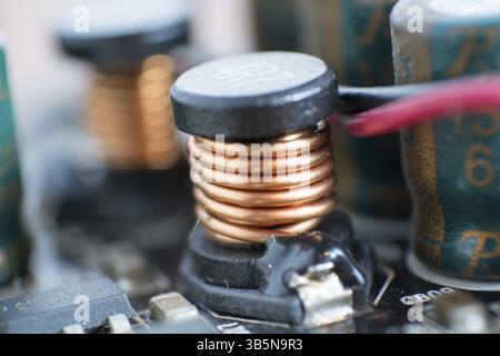 A dusty computer components. Detail of a dusty computer mainboard. Electrolytic capacitor and conductor visible on the printed circuit board. Selectiv Stock Photo