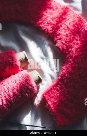 Bright pink knitting with knitting needles on white sheet. Soft pink knitwear with circle needles. Knitting pattern background. Knitting lifestyle. Stock Photo