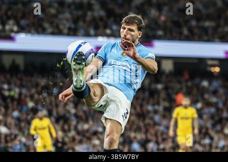 ruben-dias-of-manchester-city-clears-the-ball-up-field-under-pressure
