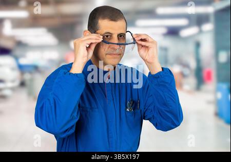 Mechanic worker putting protective glasses before work in a factory Stock Photo