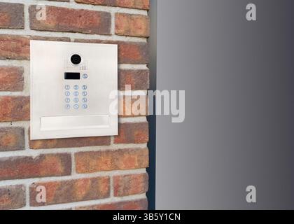 Metal Keypad Intercom on Corner Brick Wall Stock Photo