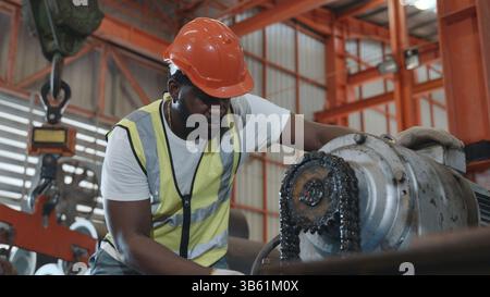 Engineer or operator wearing a safety suit maintaining machine in the industrial factory Stock Photo