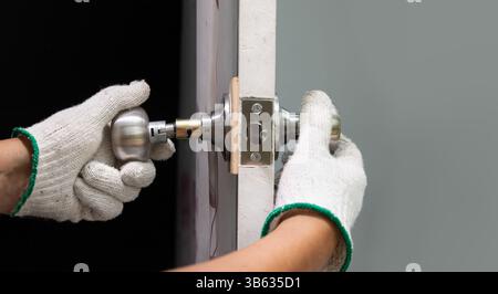 Locksmith repairing a broken door knob. Stock Photo