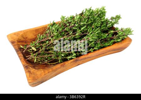 Freshly cut thyme herb sprigs in an olive wood dish isolated on a white background Stock Photo