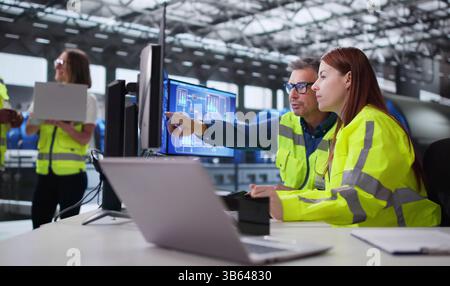 Engineer Operating Control Panel At Power Plant Generating Electricity For City. Stock Photo
