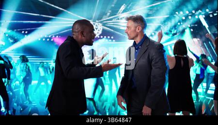 African-American Woman Catches Her Boyfriend Cheating At The Nightclub Party. A Diverse Team Of Friends Watches Stock Photo