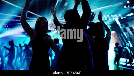 Nightclub DJ Spinning Beats, Crowd Dancing In Silhouette Motion Stock Photo