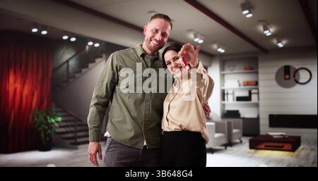 Smiling Homeowners Holding Keys To New House After Successful Purchase Stock Photo