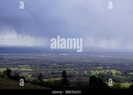 Dramatic view of the Surrey Hills with patchwork fields under dark storm clouds and rain showers. Leith Hill, England Stock Photo
