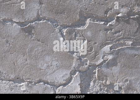 Weathered gray concrete surface with deep cracks, rough texture, and visible erosion from aging and elements. Backgrounds Stock Photo