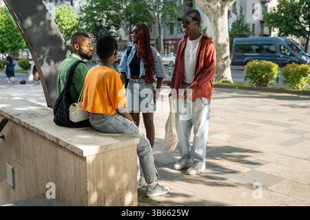 Smiling cheerful Black friends enjoying post exam downtime together. Friendly youth group having fun Stock Photo