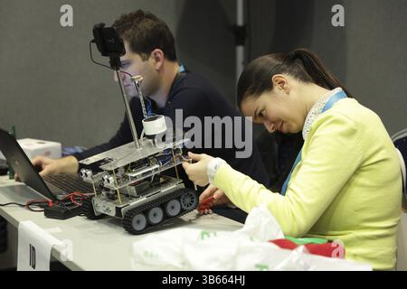 Sofia, Bulgaria - December 17, 2016: A student prepares her race robot during an open competition of self-made robots among school students Stock Photo