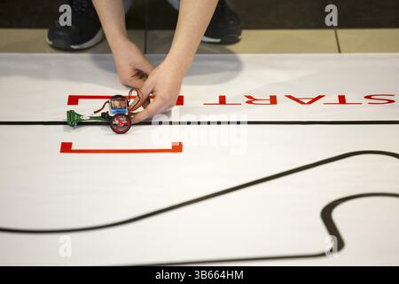 Sofia, Bulgaria - December 17, 2016: A student prepares his race robot during an open competition of self-made robots among school students Stock Photo