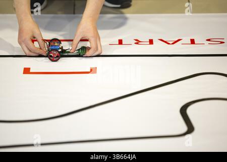 Sofia, Bulgaria - December 17, 2016: A student prepares his race robot during an open competition of self-made robots among school students Stock Photo