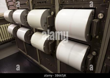 Seismograph records an earthquake on the sheet of measuring paper. Seismological device for measuring earthquakes. Seismograph machine needle drawing Stock Photo
