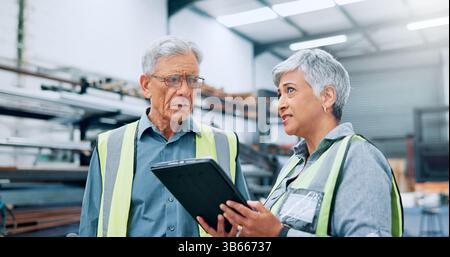People, engineer and talking with tablet at factory for planning, supply chain and inventory management. Mature staff, team and digital for Stock Photo