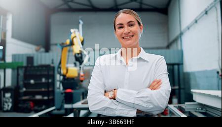 Happy, woman and engineer with portrait for robotics production, manufacturing career and industry. Smile, technician and arms crossed with pride for Stock Photo