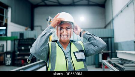 Portrait, woman and engineer with helmet for robotics production, manufacturing career and industry. Happy, mature person and technician with Stock Photo