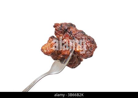 Two traditional Romanian grilled minced meat, mici or mititei on a metal fork close up isolated on white Stock Photo