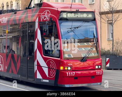 Nuremberg , Germany, 2025 Februar 8thTram: A red tram with black and white graphics is shown in a close up, capturing the reflection of buildings in i Stock Photo