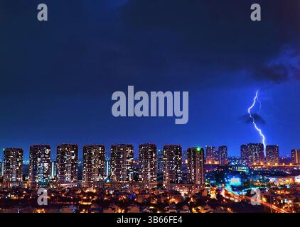 Dramatic lightning strike over modern city skyline at night – Urban storm and cityscape photography Stock Photo